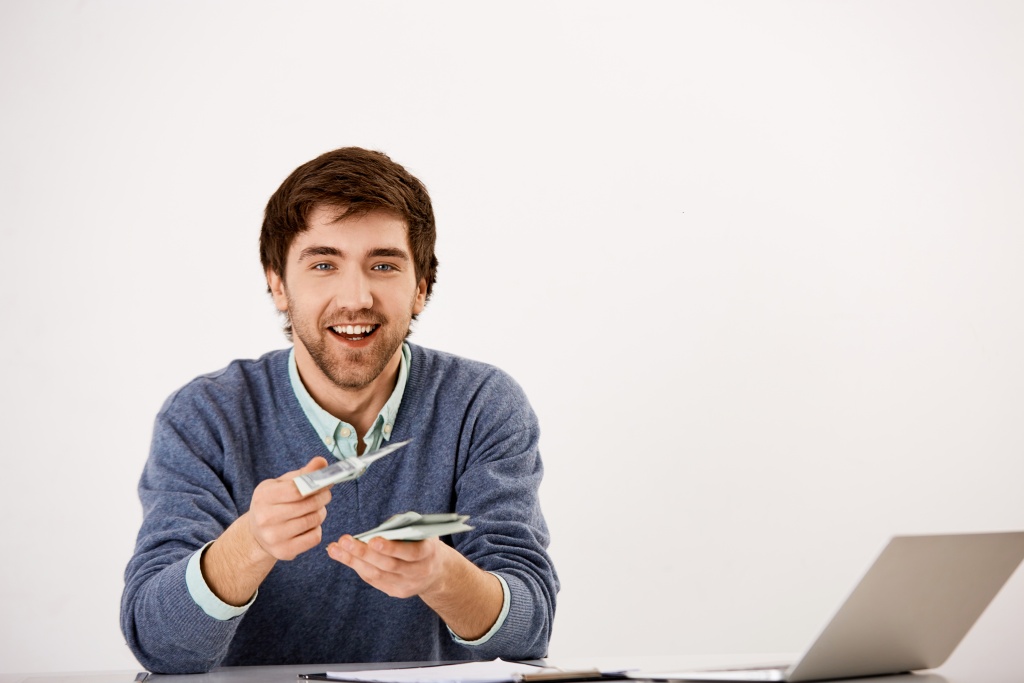 young-smiling-businessman-give-cash-sit-desk-with-laptop-counting-money-give-half-income-business-partner.jpg мужчина
