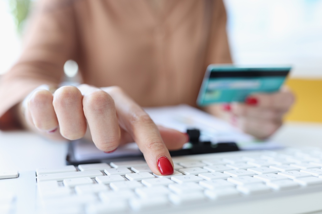 woman-hand-holds-bank-card-works-computer-keyboard.jpg красные ногти